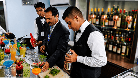 Bartenders training behind a bar