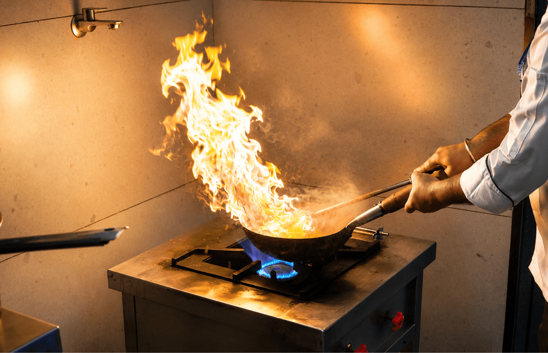 Chef flambéing food in a professional kitchen